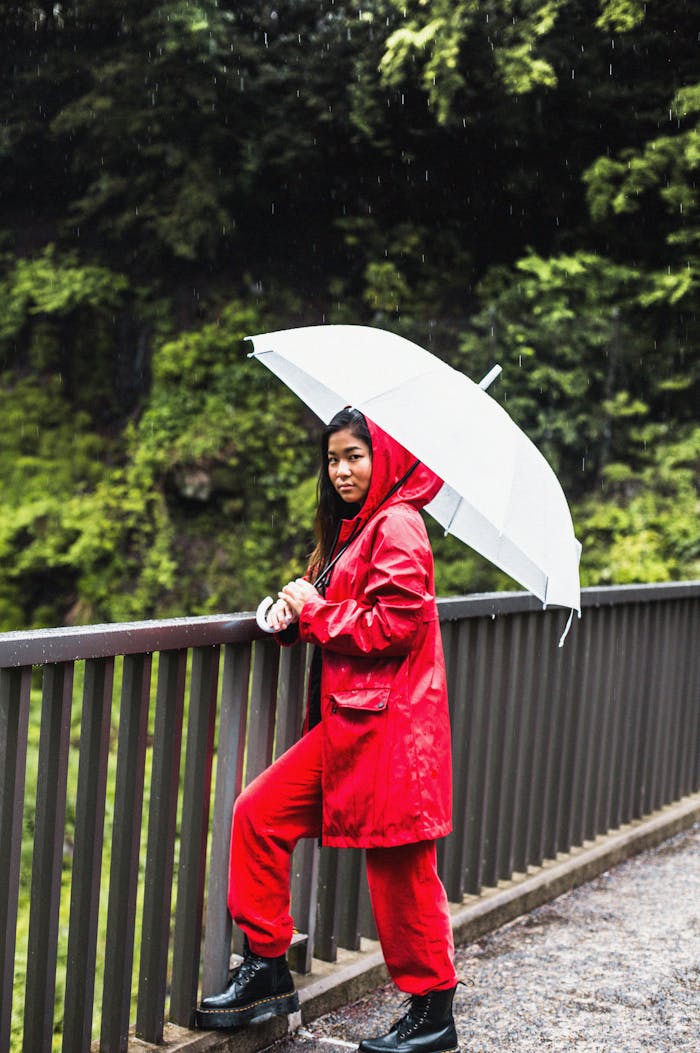 Asian woman in a red raincoat holding an umbrella on a rainy day in Fujinomiya, Japan.